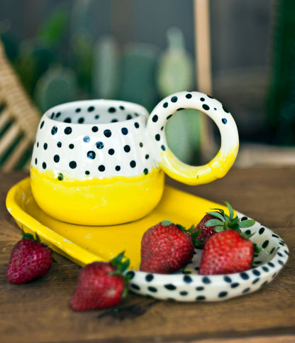 Filiżanka żółta w kropki z talerzem deserowym