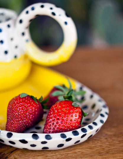 Filiżanka żółta w kropki z talerzem deserowym