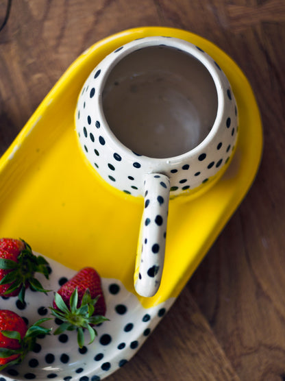 Filiżanka żółta w kropki z talerzem deserowym